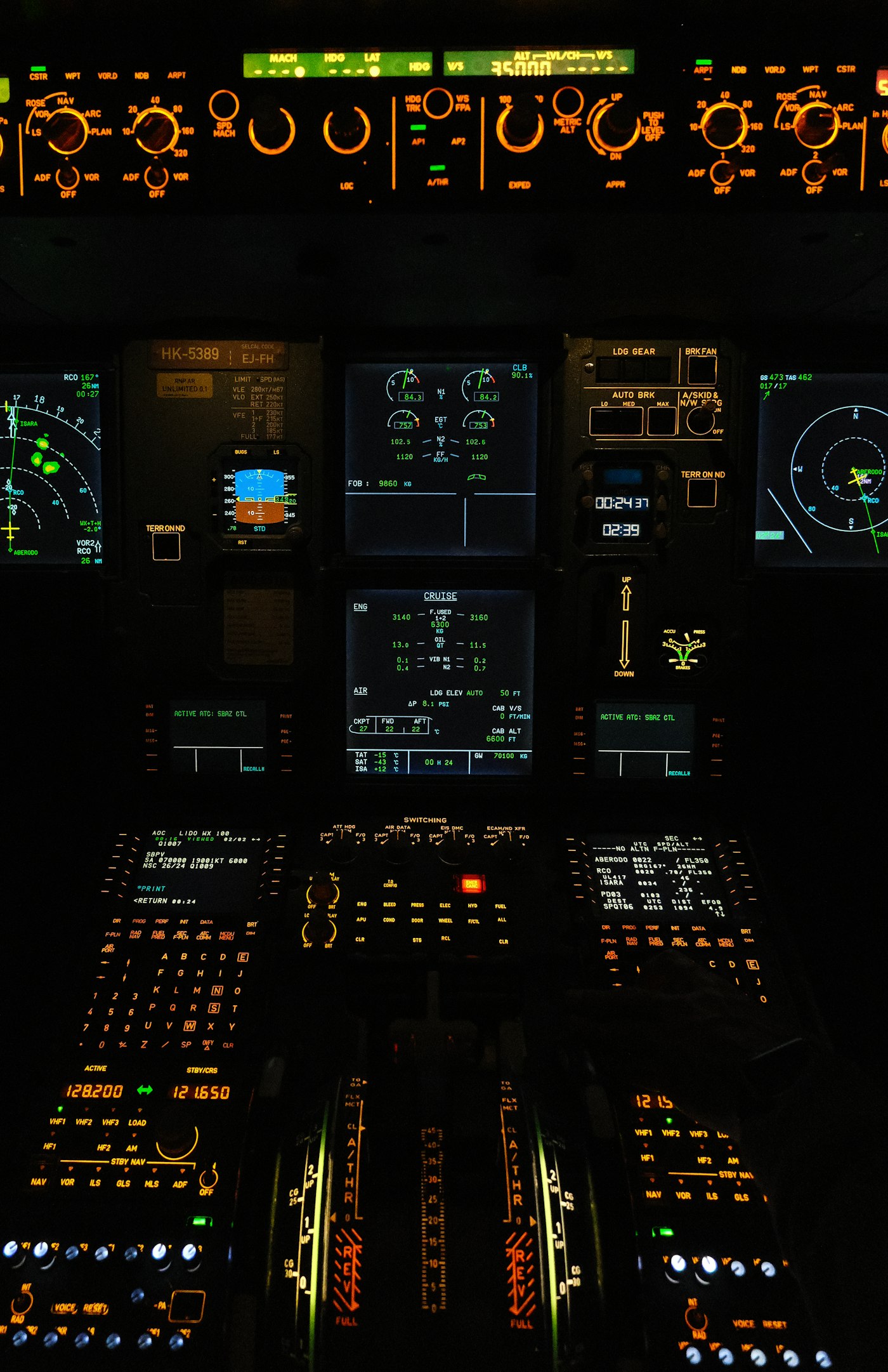 An airliner flight deck at night, displays lit